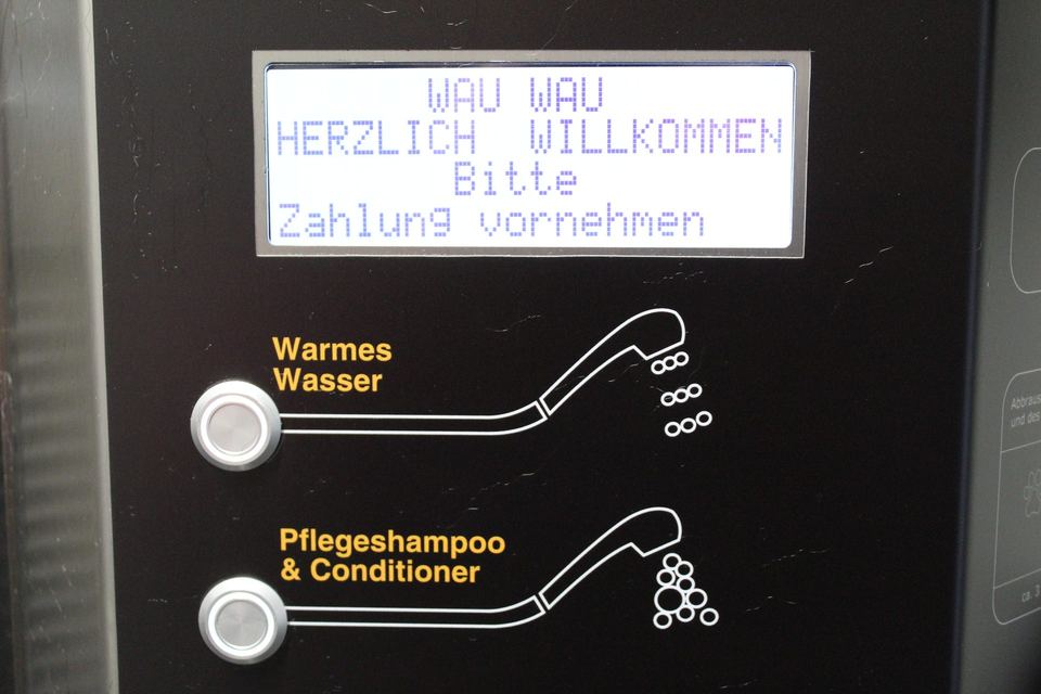 Bedienfeld der Hundewaschanlage mit Display „Wau Wau – herzlich willkommen“ und Wahltasten für warmes Wasser sowie Pflegeshampoo und Conditioner